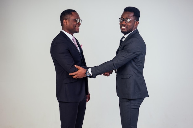 Handshake mit afroamerikanischem Bankmanager und dunkelhäutigem Eigentümer CEO Geschäftsmann im Studio auf weißem Hintergrund. multinationales Teamwork High Five Handshaking