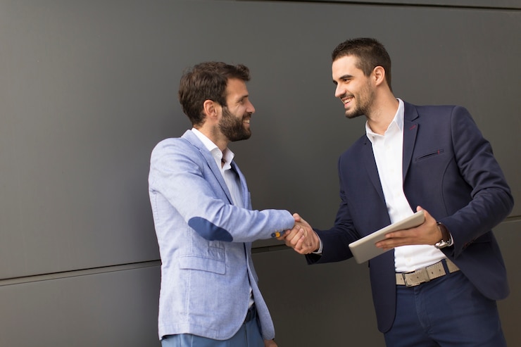 Foto handshaking de jovens empresários pelo prédio de escritórios