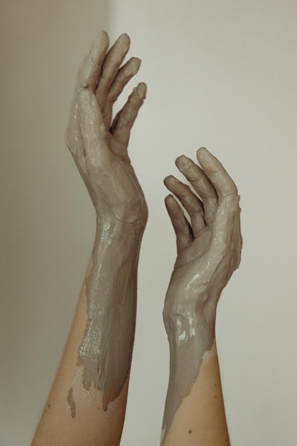 Handskulpturen, die mit weißem Ton bedeckt sind