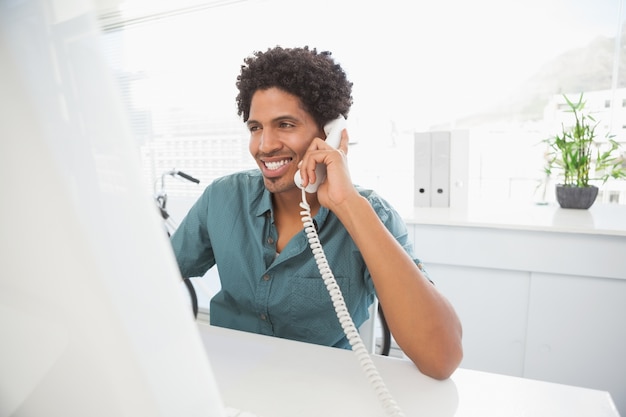 Handsome businessman falando no telefone na mesa