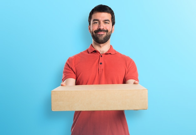 Handsome Mann hält Boxen auf bunten Hintergrund