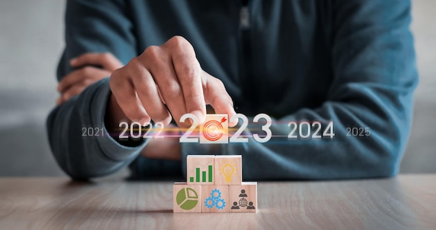 Handstapelholzblockschritt auf Tisch mit Symbol Aktionsplan Ziel- und Zielerfolg und Geschäftszielkonzept Projektmanagement Unternehmensstrategieentwicklung positive Indikatoren im Jahr 2023