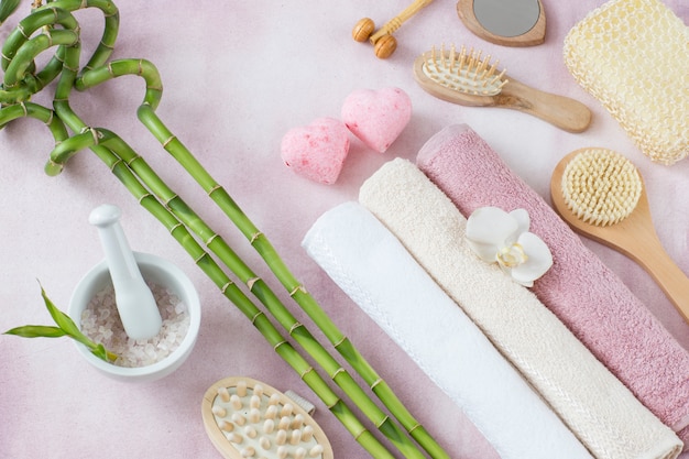 Handtücher, Meersalz, Bambus und Seife in Form von zwei rosa Herzen