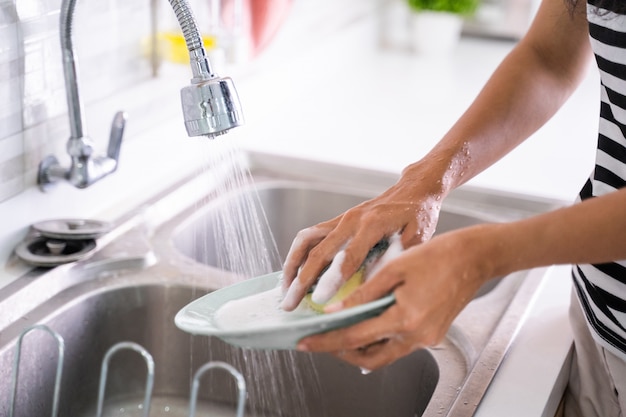 Handwäsche eines Tellers auf einem Waschbecken