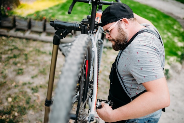 Handwerker arbeitet mit Fahrradrad, Fahrradwerkstatt