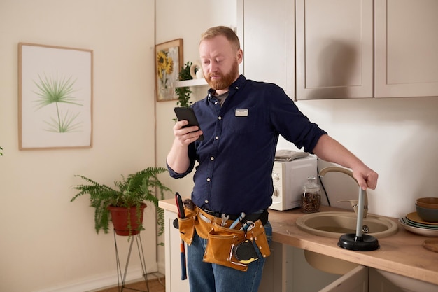 Handwerker mit Handy während seiner Arbeit