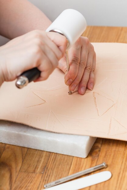 Foto handwerker setzt prägung auf leder