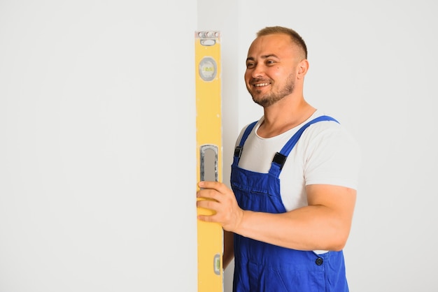 Handwerker überprüfen die Ebenheit der Wand mit einer Wasserwaage.