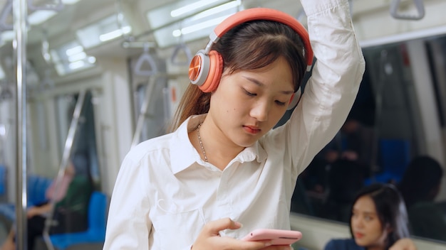 Handy der jungen Frau im öffentlichen Zug
