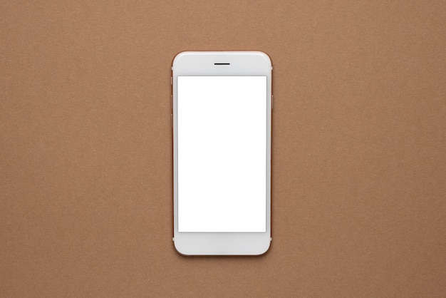 Handy mit weißem Bildschirm auf hellbraunem Hintergrund. Trend, minimales Konzept mit Copyspace-Draufsicht
