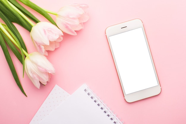 Handy, notebook und frühlingsblume rosa tulpen auf dem rosa