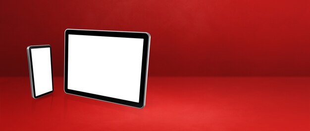 Handy und digitaler Tablet-PC auf rotem Schreibtisch.