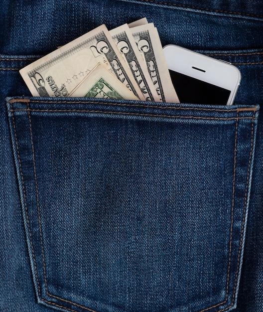 Handy und Dollarnoten in der Jeanstasche