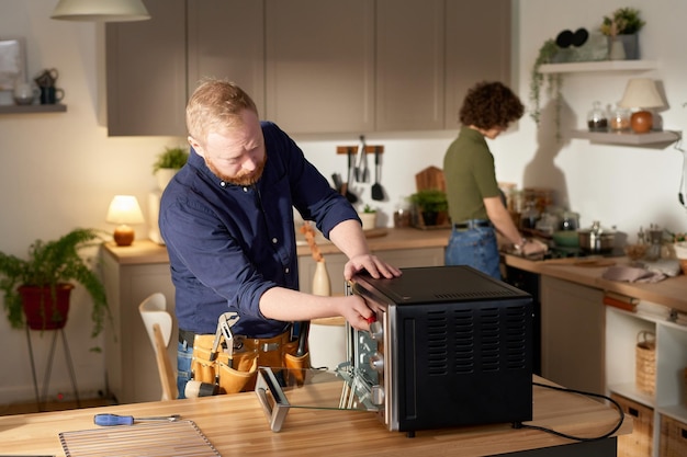 Handyman consertando forno em casa