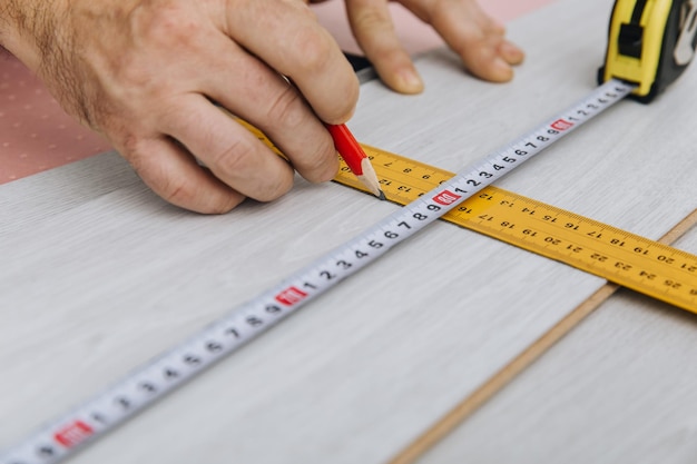 Handyman instalando un nuevo piso de madera laminada