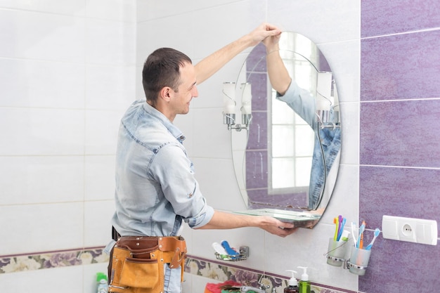 Handyman instalando um espelho no banheiro.