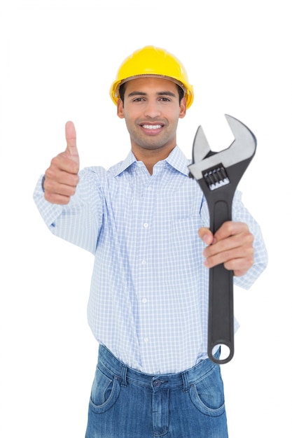 Handyman segurando uma chave enquanto gesticula polegares para cima