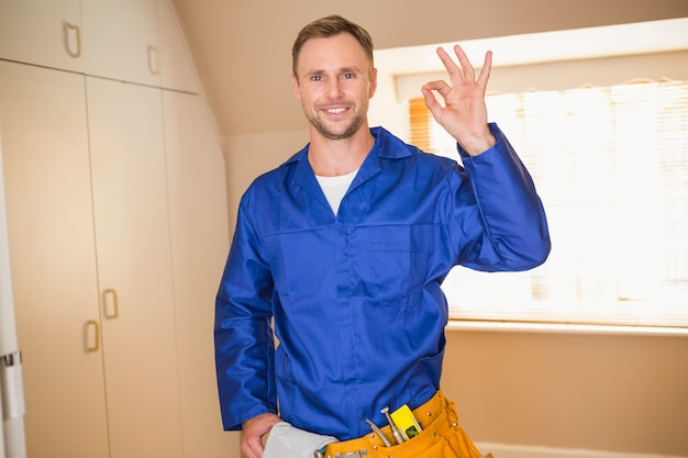 Handyman sorrindo na câmera no cinto de ferramentas