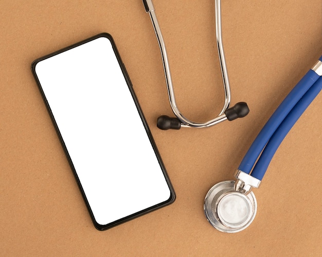 Handymodell mit Stethoskop. Vorlage mit weißem Bildschirm des Smartphones am Schreibtisch für medizinische Anwendungen.