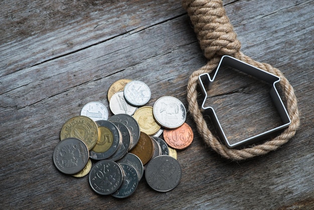 Foto hangman's schlinge mit haus und geld auf brauner holzoberfläche