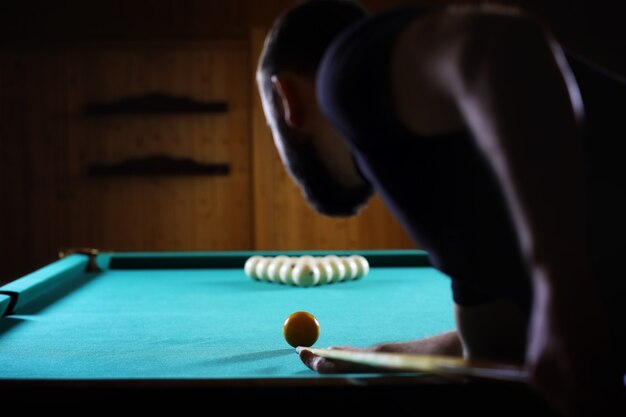 Foto hansome homem jogando bilhar sozinho em uma grande sala