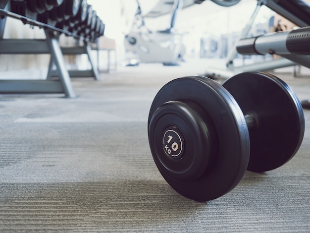 Hantel auf dem Boden in der Turnhalle. Gesund und Fit Konzept.