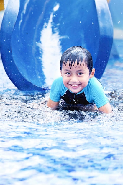 Happy Asian Kid auf einer Wasserrutsche