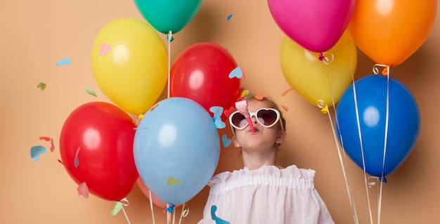 Happy Birthday Party Kindermädchen mit Luftballons auf beigem Hintergrund