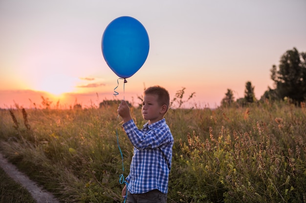 Happy Boy hace sus deseos y sueños al aire libre con globo Hermosa libertad de tarjeta de verano