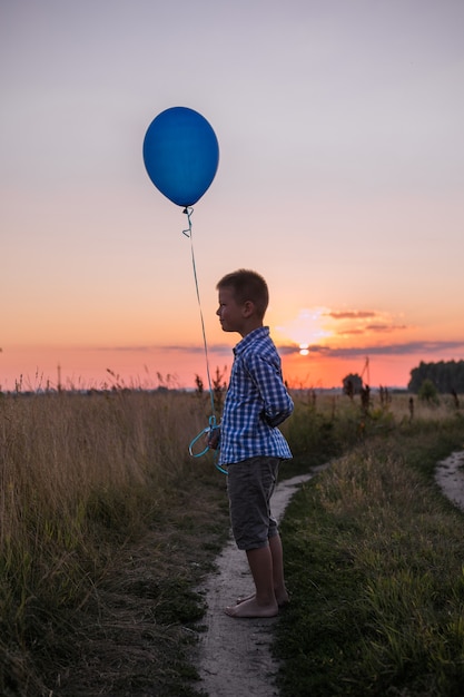 Happy Boy hace sus deseos y sueños al aire libre con globo Hermosa libertad de tarjeta de verano