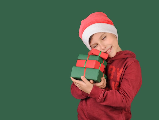 Foto happy boy hält ein geschenk auf grünem hintergrund