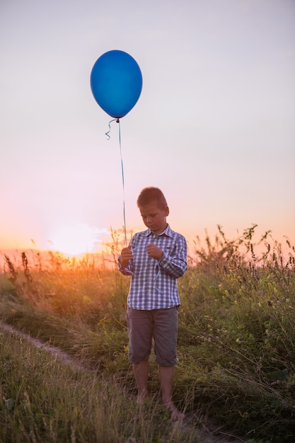 Happy Boy macht seine Wünsche und Träume im Freien mit Ballon Schöne Sommerkartenfreiheit