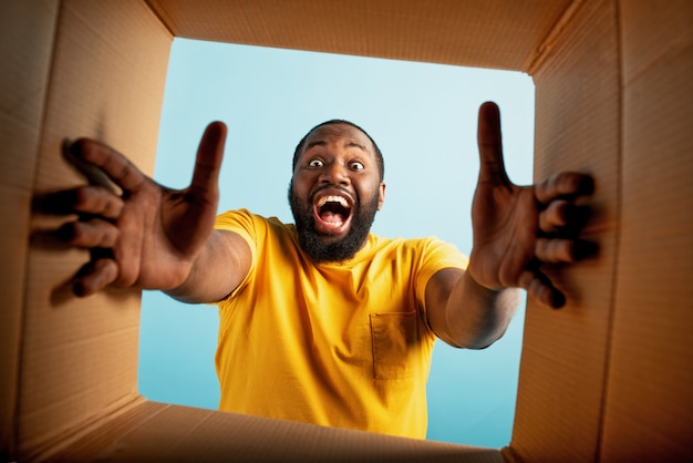 Happy boy recibe un paquete del pedido de la tienda en línea. expresión feliz y sorprendida