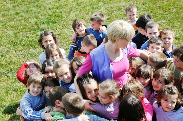 Happy Child Kids Group hat Spaß und spielt im Kindergarten-Vorschulbildungskonzept mit Lehrer