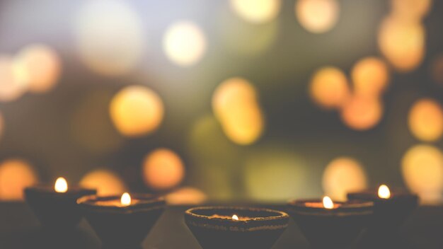 Happy Diwali - Lámparas Clay Diya encendidas durante Dipavali, celebración del festival hindú de las luces. Lámpara de aceite tradicional colorida diya sobre fondo oscuro. Copie el espacio para el texto.