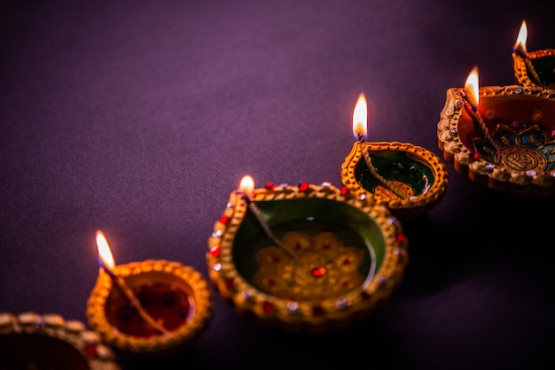 Happy Diwali - Schöne Diwali Diyas in der Nacht mit Blumen