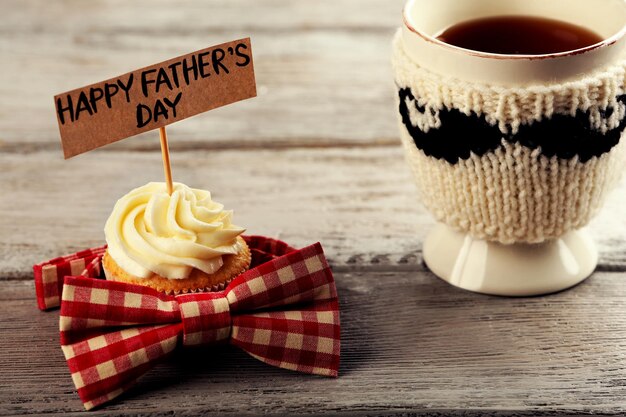 Happy Fathers Day Special Cupcake Tasse Tee und Fliege auf Holztisch