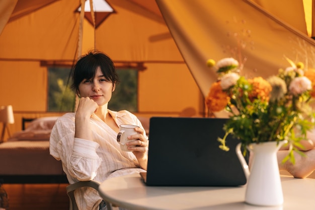 Happy Girl Entspannung im Urlaub Camping junge Frau sitzt im Lagerzelt Junge weibliche kaukasischen Modell Lesetext und Arbeit am Notebook