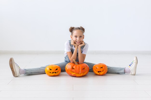 Happy Halloween, Herbstferien und Kindheitskonzept - Nettes kleines Mädchen mit einer Kürbis-Kürbislaterne drinnen.