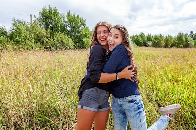 Happy People Konzept Gruppe von zwei Freundinnen tanzen umarmen und Spaß zusammen im Freien haben