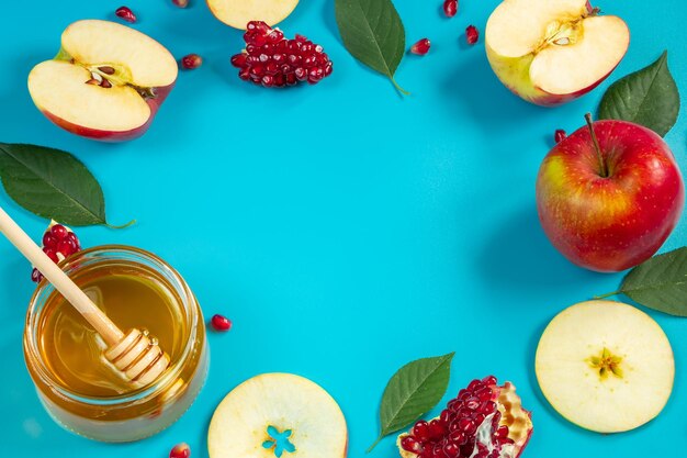 Happy Rosh Hashanah Honigäpfel und Granatäpfel auf blauem Hintergrund Runder Rahmen für Ihren Text Jüdischer traditioneller religiöser Feiertag