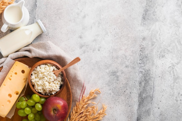 Happy Shavuot Hintergrund für Shavuot-Feier Milch und Käse reifer Weizen und Früchte blauer Holzhintergrund Milchprodukte über alten grauen Tisch Betonhintergrund Shavuot-Konzept Mock-up