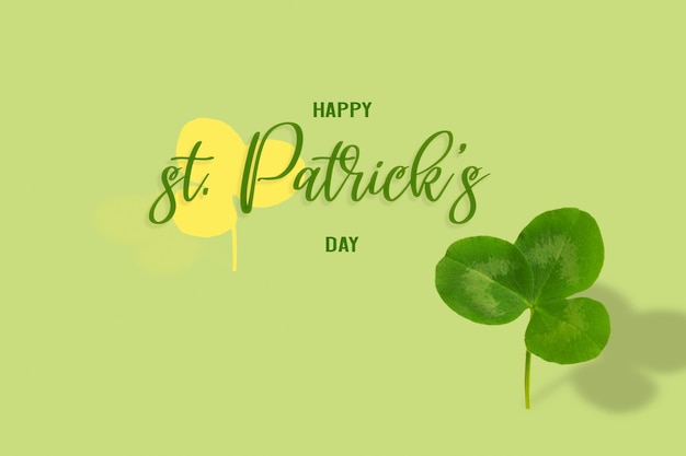 Happy St. Patrick's Day Text mit Kleeblatt auf farbigem Hintergrund