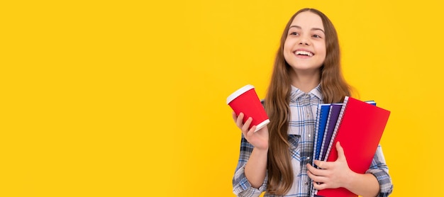 Happy Teen Girl in kariertem Hemd mit Kaffeetasse und Notebook auf gelbem Hintergrund Bildung Banner der Schülerin Schulkind Schüler Porträt mit Kopie Raum