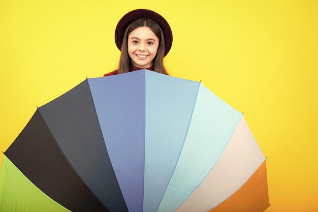Happy Teenager-Porträt Herbst-Kinder-Konzept Kind Teenager-Mädchen bedeckt Gesicht unter Regenschirm im Herbst Hut auf gelben Studio-Hintergrund Lächelndes Mädchen