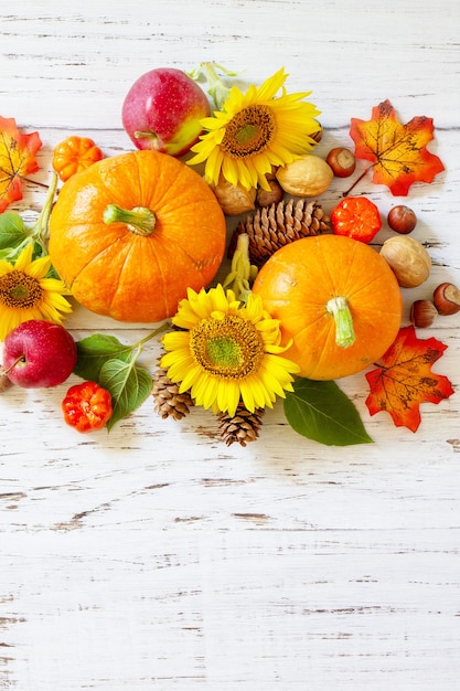 Happy Thanksgiving-Konzept Kürbisse Sonnenblumen Äpfel und abgefallene Blätter Draufsicht Textfreiraum