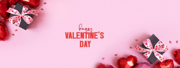 Foto happy valentines day text auf grußkarte banner mit geschenkbox mit ballons in bogen- und herzform auf rosa hintergrund