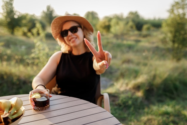 Happy Woman Freelancer trinken Cocktails und entspannen sich an sonnigen Tagen in einem gemütlichen Glamping-Zelt Luxus-Campingzelt für Sommerferien und Urlaub im Freien Lifestyle-Konzept