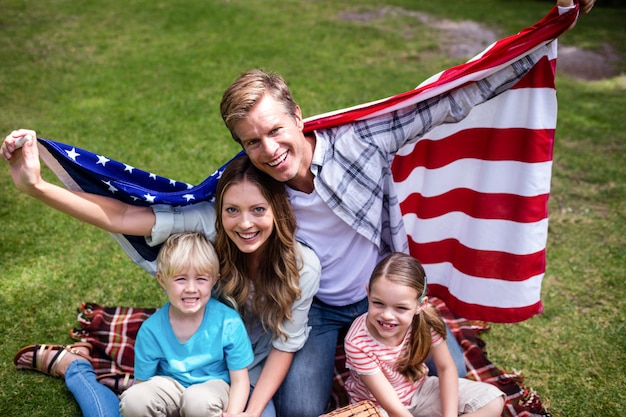 Hapy-Familie, die amerikanische Flagge im Park hält