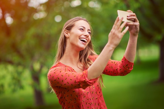 Esto hará una gran foto de perfil Foto de una mujer joven tomando un selfie afuera